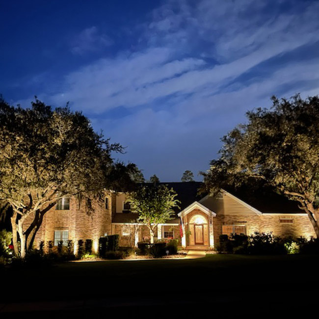 brick home with exterior lighting