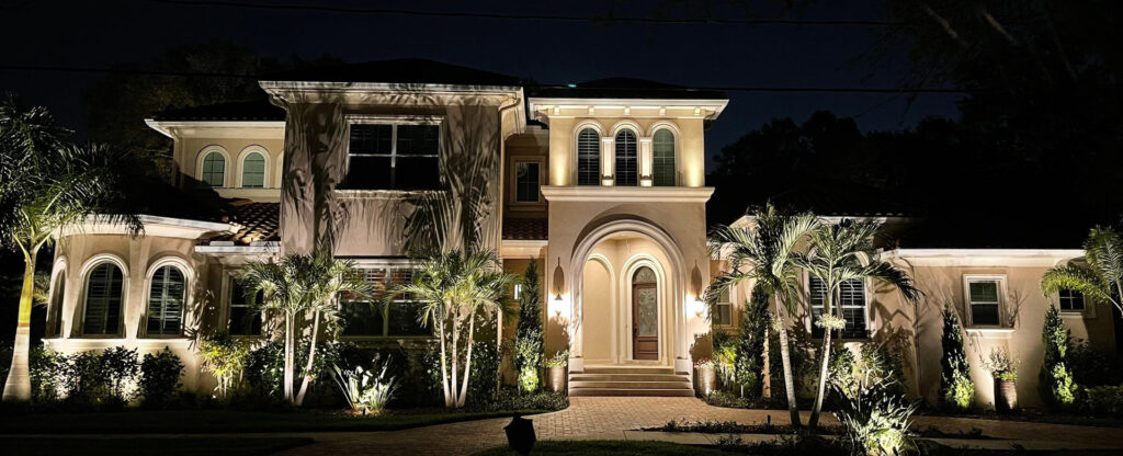 brick home with exterior lighting at night